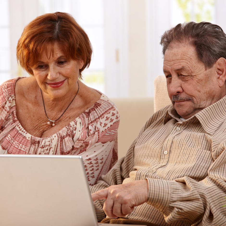 Foto de una mujer y un hombre mayor usando un computador portátil.