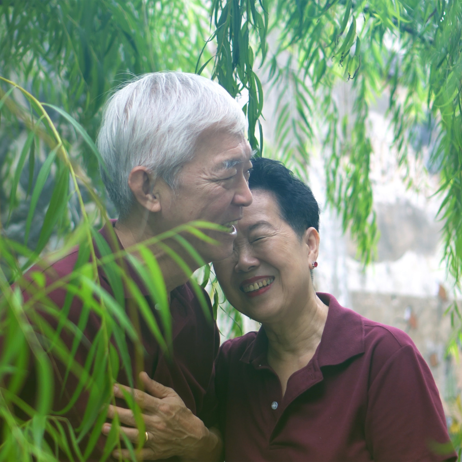 Foto de una pareja de personas mayores de China, abrazados y sonriendo.
