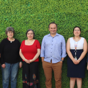 Foto de distintas personas de pie posando para una foto en un patio exterior.