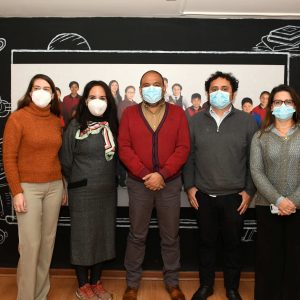 Foto de 5 personas sonriendo y mirando a la cámara, de pie al interior de una oficina.