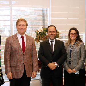 Foto de cinco personas sonriendo de pie mirando a la cámara.