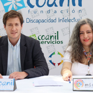 Foto de Nicolás Fehlandt de Coanil y Claudia Miranda de MICARE en una mesa firmando el convenio.