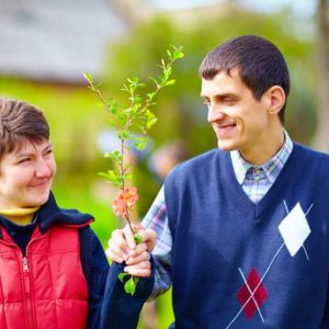 portrait of happy woman and man with disability together on spring lawn