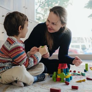 Mother And Son Playing With Toy Blocks At Home