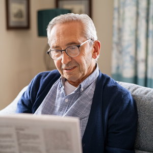 Foto de un hombre mayor leyendo un periódico.