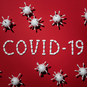 Gráfica que muestra representaciones en 3D del virus del COVID-19 y al centro está escrito COVID-19 con medicamentos.