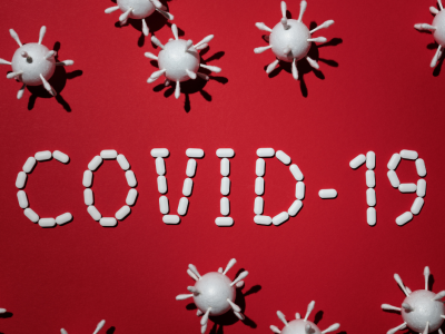 Gráfica que muestra representaciones en 3D del virus del COVID-19 y al centro está escrito COVID-19 con medicamentos.