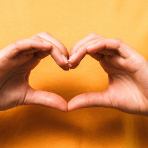 person doing a heart sign with their hands